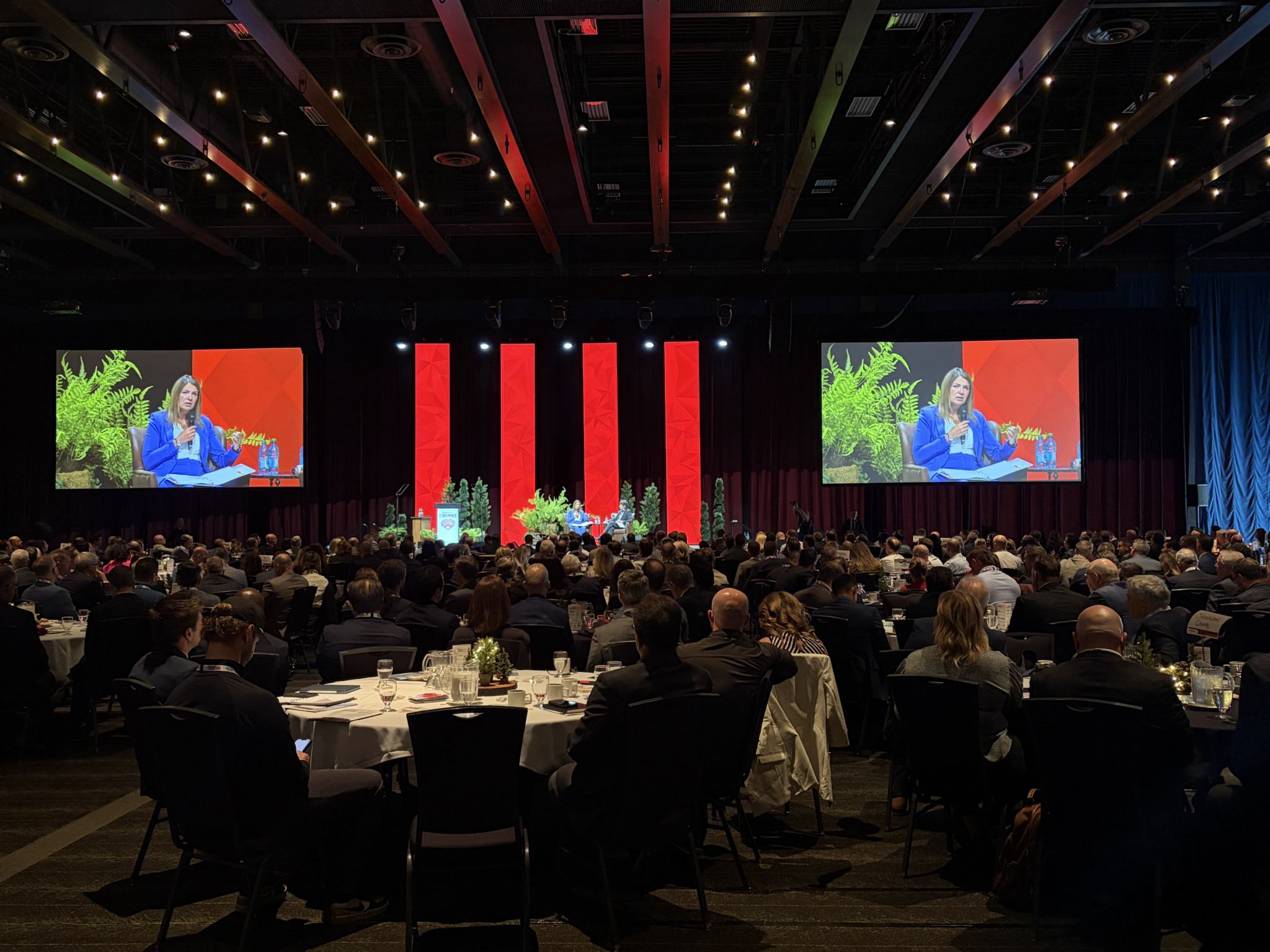 AIHA Annual Conference at Edmonton Convention Centre Hall D featuring large projection screens, LED video wall pillars and stage lighting by Kiwi Productions.