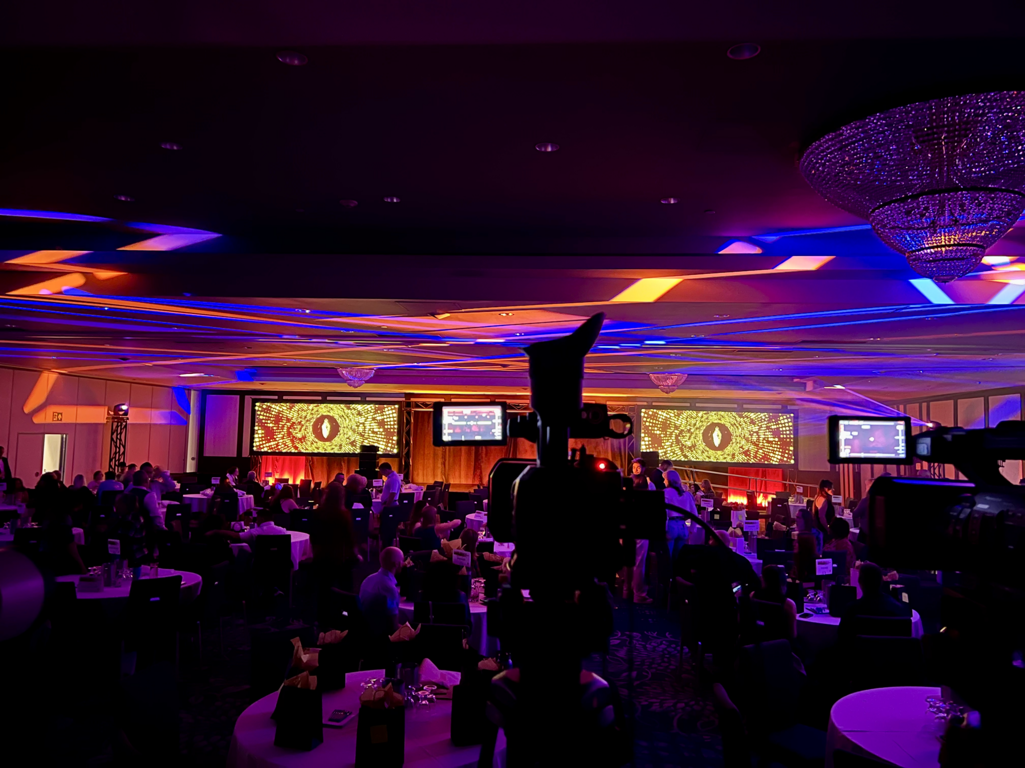 Corporate event AV production at Delta Edmonton South hotel featuring two widescreen projection screens, stage lighting and audiovisual equipment by Kiwi Productions.